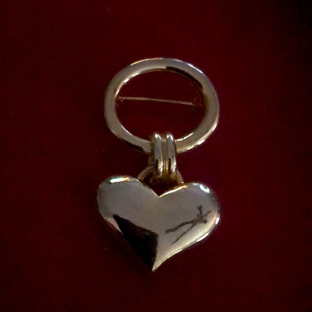 Gold tone heart hanging from circle.